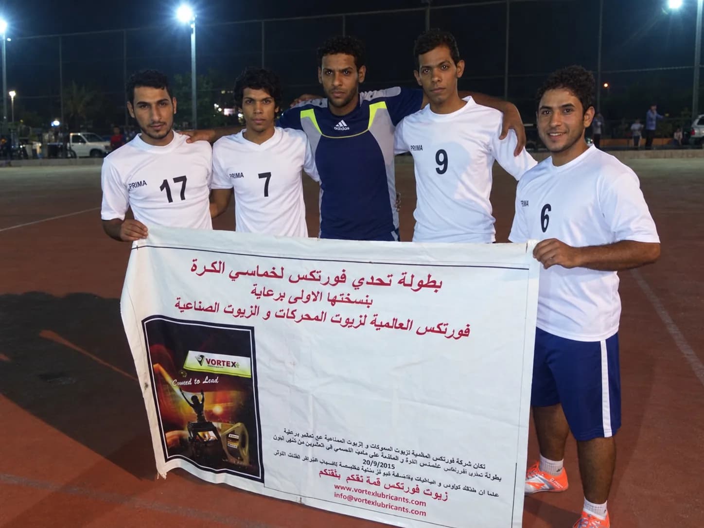 Five players in white holding the Vortex Challenge tournament banner, their goalkeeper in navy among them